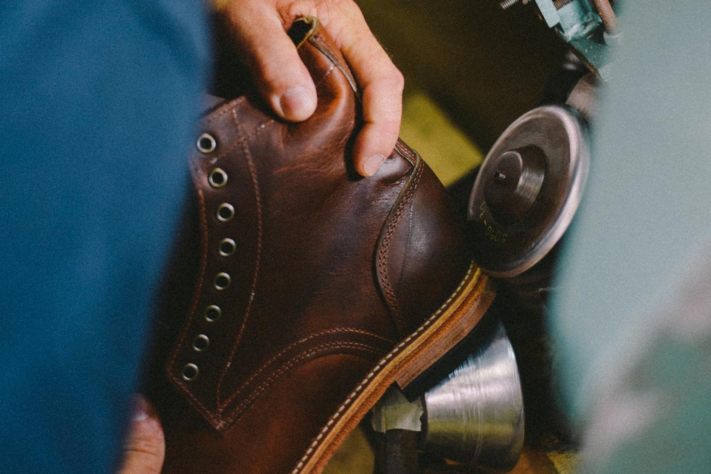 A bootmaker polishes the new sole fitted to a pair of Trench Boots being recrafted